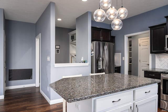 5138 Indigo Ave, Lafayette, IN 47909 - kitchen featuring dark stone countertops, appliances with stainless steel finishes, tasteful backsplash, and dark wood-style floors