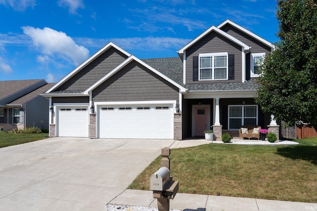 5138 Indigo Ave, Lafayette, IN 47909 - craftsman house featuring covered porch, stone siding, driveway, a garage, and a front lawn