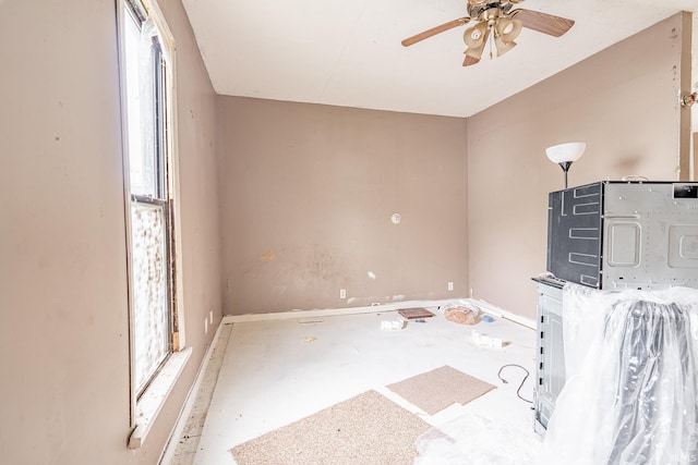unfurnished room with ceiling fan, baseboards, and plenty of natural light