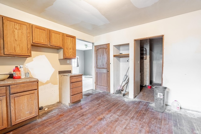 kitchen with brown cabinetry, tile countertops, and dark wood-type flooring