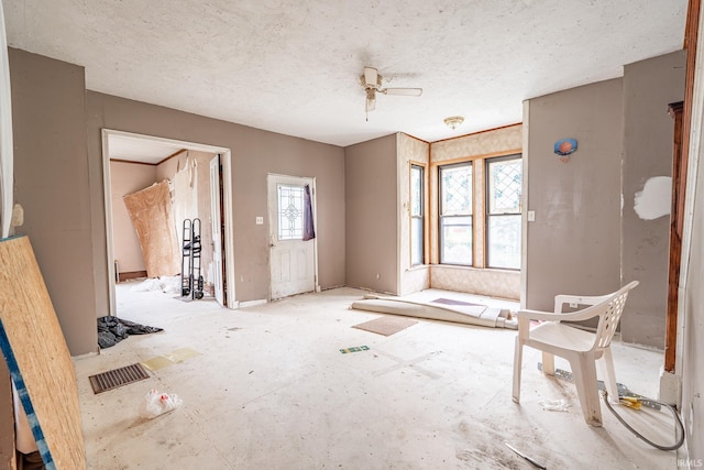 empty room with ceiling fan, a textured ceiling, and visible vents