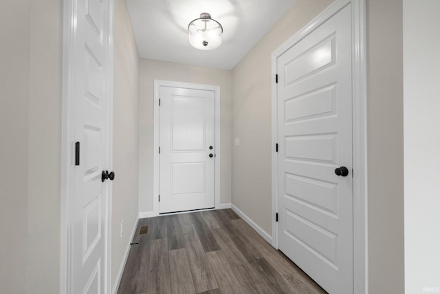entryway featuring dark wood-style flooring, baseboards, and visible vents