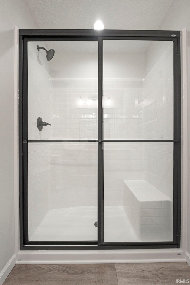full bathroom featuring a stall shower and baseboards