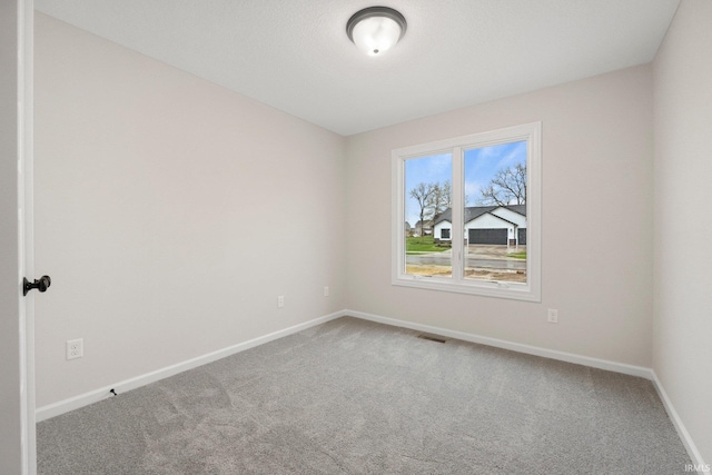 carpeted empty room with baseboards
