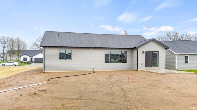 view of front facade featuring a patio and a shingled roof