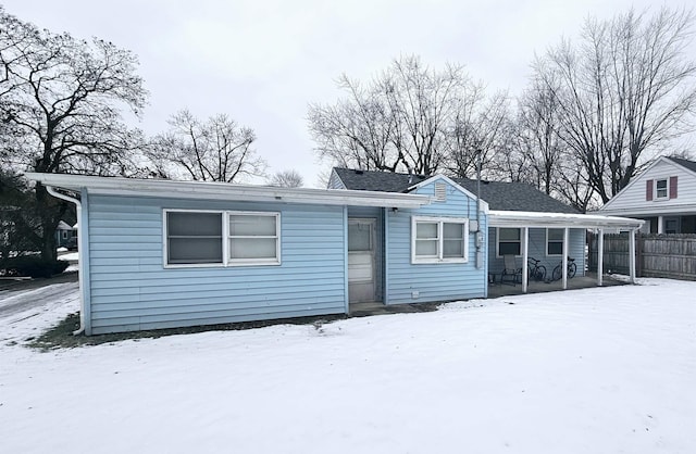 ranch-style house featuring covered porch and fence