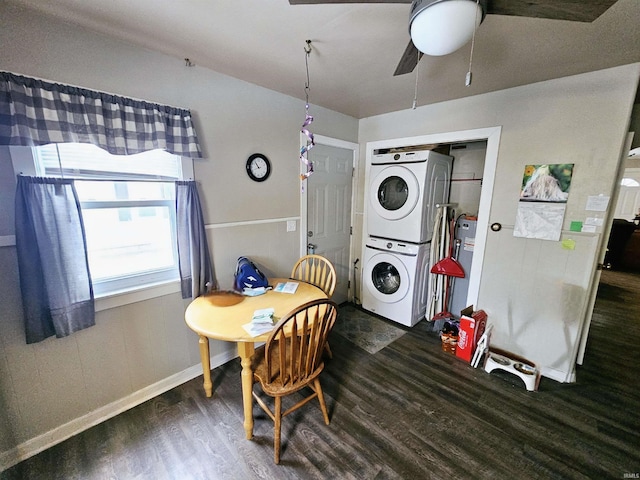 dining space featuring stacked washer and dryer, baseboards, a ceiling fan, and wood finished floors