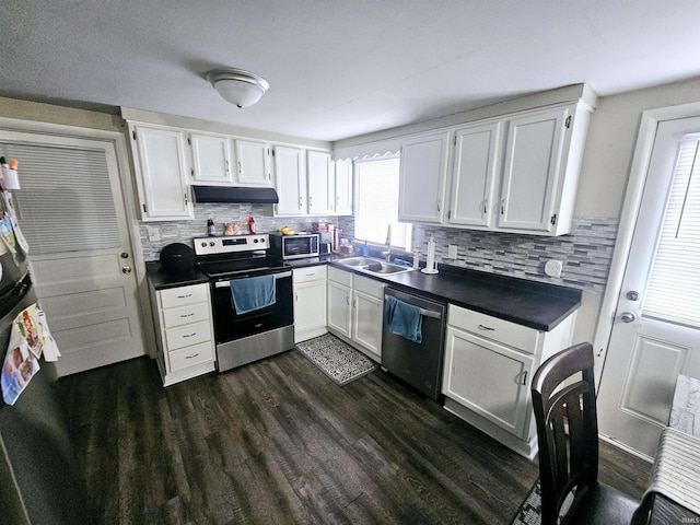 kitchen featuring dark countertops, white cabinets, appliances with stainless steel finishes, and under cabinet range hood