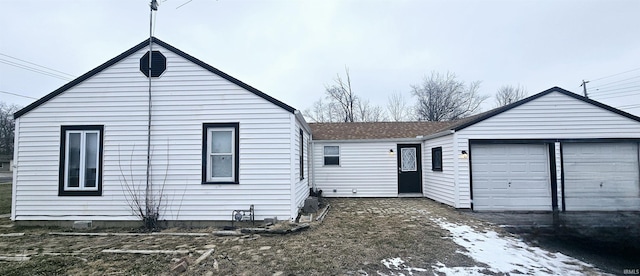 view of front of house with a garage and a shingled roof