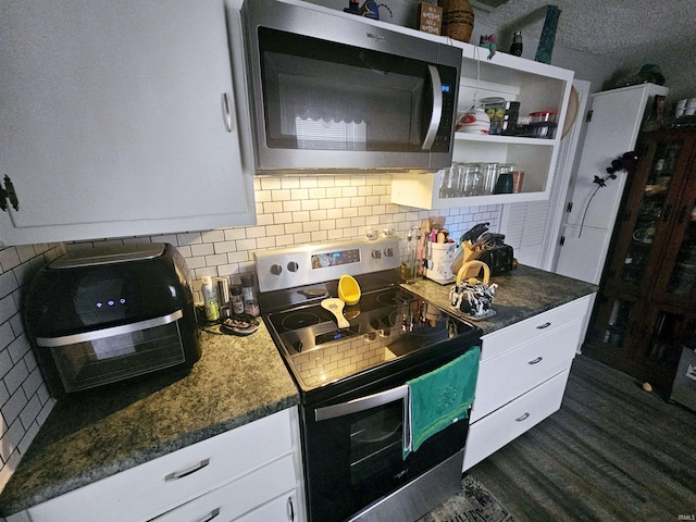 kitchen featuring white cabinets, appliances with stainless steel finishes, and backsplash