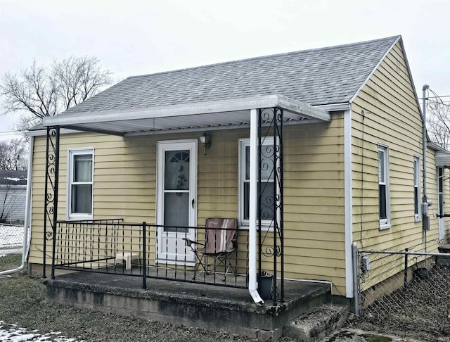 view of front of home featuring a shingled roof and fence