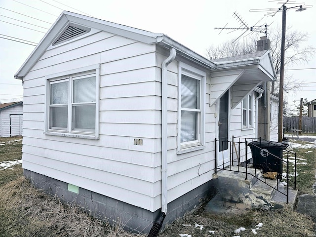 view of property exterior with fence and a chimney