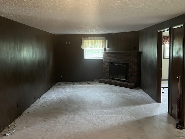 388 Schuetter Rd, Jasper, IN 47546 - unfurnished living room featuring carpet flooring, a textured ceiling, wood walls, and a brick fireplace