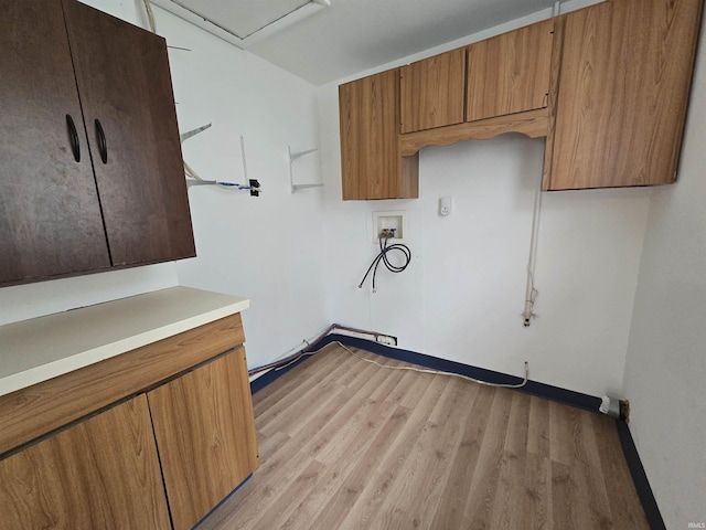 laundry area featuring light wood finished floors, cabinet space, baseboards, and hookup for a washing machine