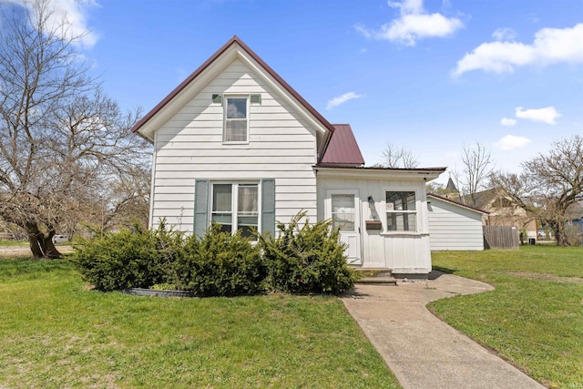 back of house with a yard and metal roof