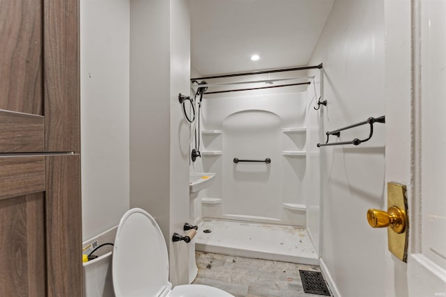 bathroom with toilet, visible vents, and a shower stall