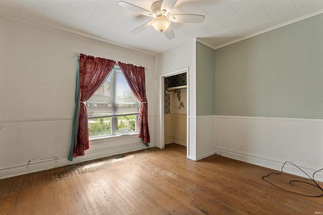 empty room featuring ornamental molding, visible vents, hardwood / wood-style floors, and ceiling fan
