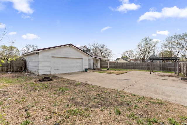 exterior space with concrete driveway, fence private yard, and a garage