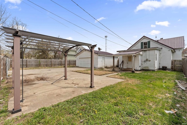 view of yard with a patio, a pergola, an outdoor structure, a fenced backyard, and a detached garage