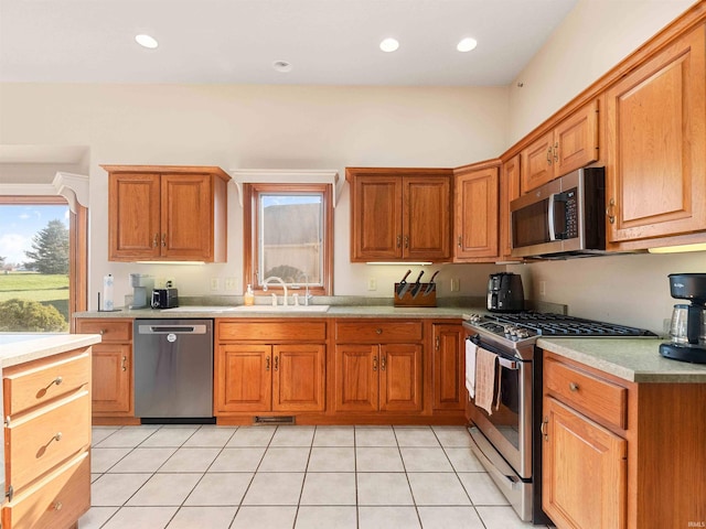 1908 Bent Tree Ct, Auburn, IN 46706 - kitchen with light tile patterned floors, a sink, brown cabinetry, light countertops, and appliances with stainless steel finishes