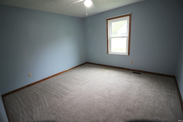 carpeted empty room with a ceiling fan, baseboards, and visible vents