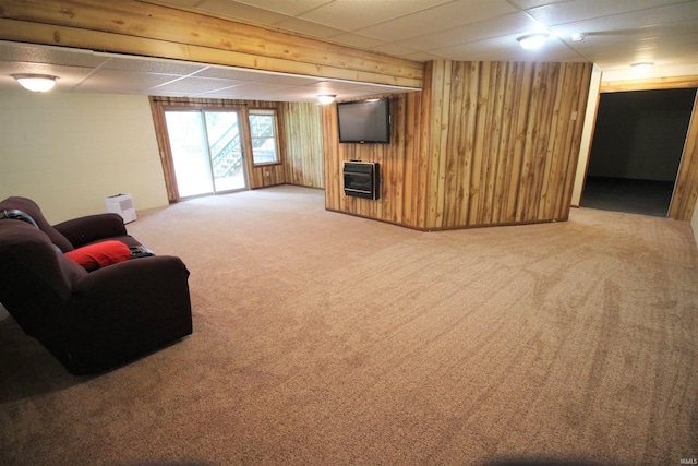 carpeted living room with wood walls