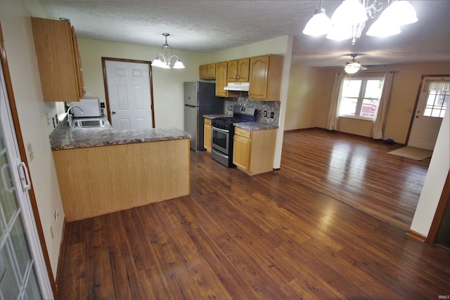 kitchen with stainless steel appliances, dark wood-style flooring, ceiling fan with notable chandelier, and a sink