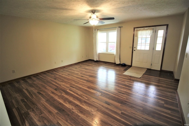 foyer entrance with ceiling fan, a textured ceiling, baseboards, and dark wood-style floors