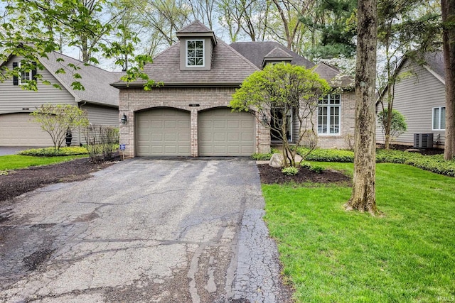 1611 Rockwood Ln, Mishawaka, IN 46545 - view of front of house featuring brick siding, a garage, central AC, aphalt driveway, and a front lawn