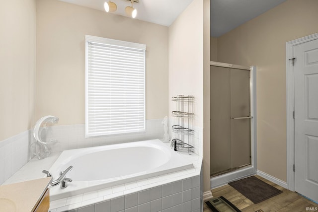 1611 Rockwood Ln, Mishawaka, IN 46545 - full bathroom featuring a stall shower, vanity, a garden tub, and wood finished floors