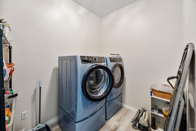 1611 Rockwood Ln, Mishawaka, IN 46545 - laundry area featuring laundry area, light wood-style floors, baseboards, and washing machine and clothes dryer