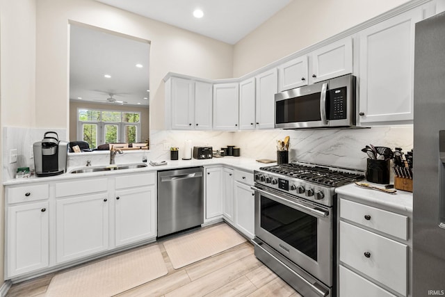1611 Rockwood Ln, Mishawaka, IN 46545 - kitchen with a sink, stainless steel appliances, recessed lighting, white cabinetry, and light countertops