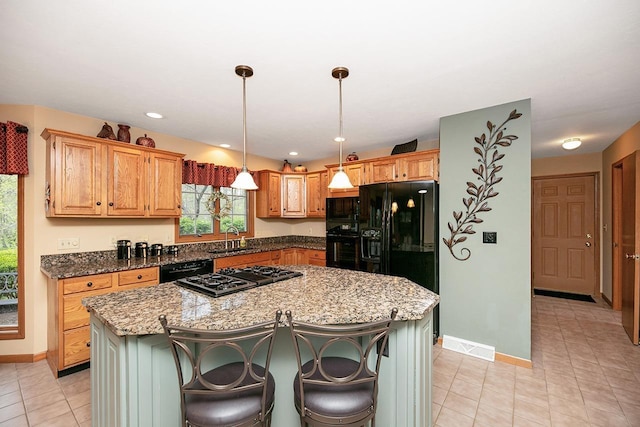 kitchen featuring a sink, light stone counters, a kitchen island, and black appliances