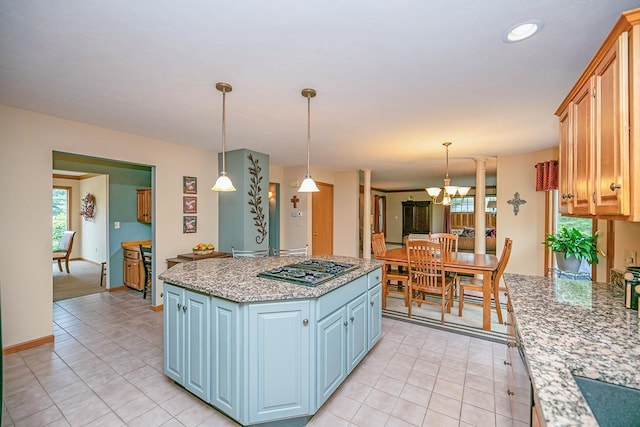 kitchen featuring gas stovetop, an inviting chandelier, light tile patterned flooring, and a kitchen island