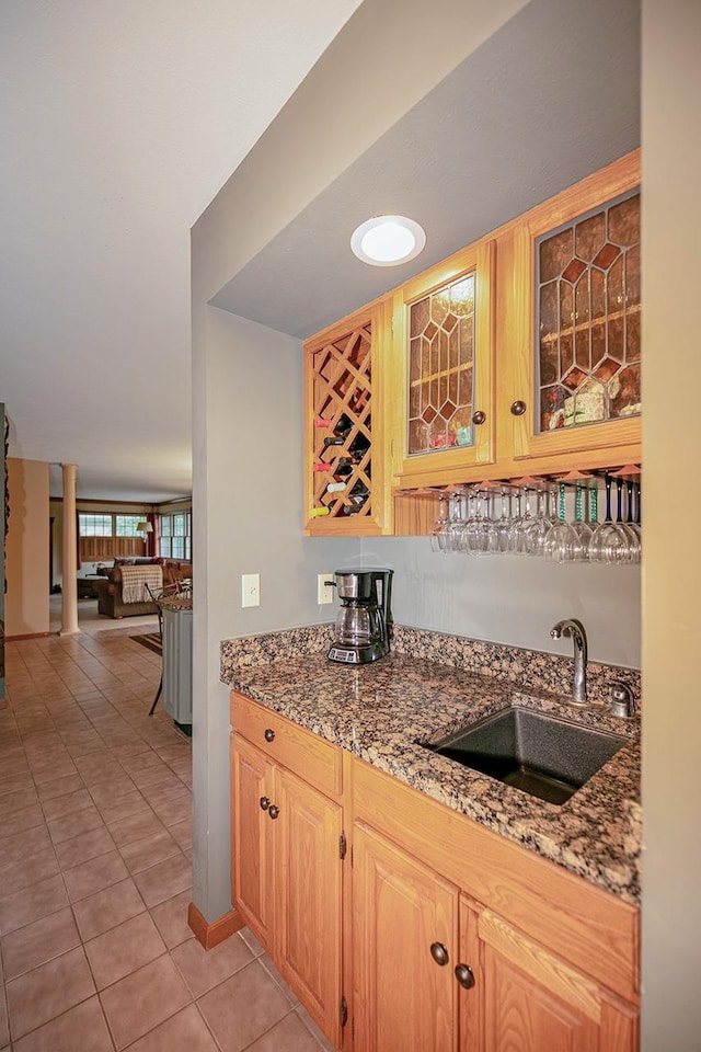 bar featuring light tile patterned floors, indoor wet bar, and a sink
