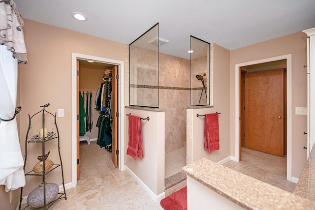 bathroom featuring baseboards, recessed lighting, visible vents, and a walk in shower