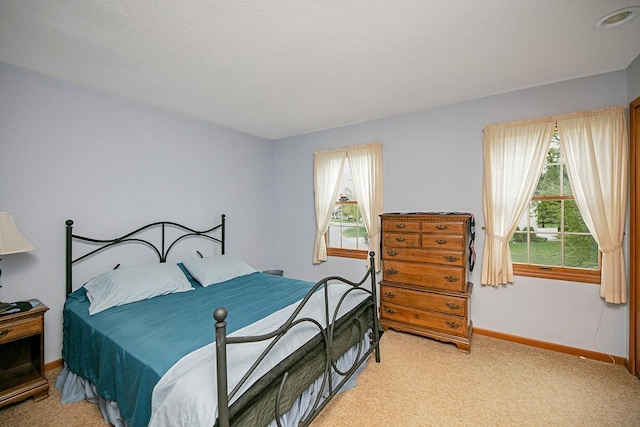 bedroom featuring baseboards and light colored carpet