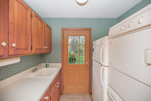 laundry area with a sink, light tile patterned flooring, washer / dryer, and wallpapered walls