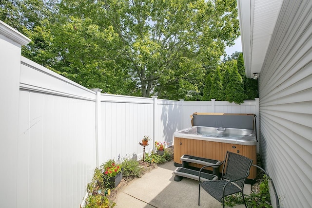 view of patio featuring a hot tub and a fenced backyard