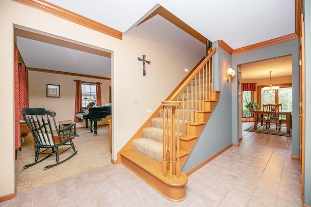 stairway featuring an inviting chandelier, ornamental molding, baseboards, and a healthy amount of sunlight