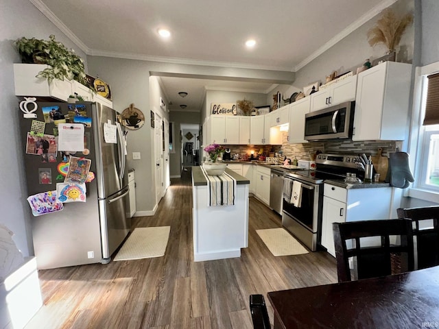 kitchen featuring a center island, crown molding, backsplash, stainless steel appliances, and white cabinets
