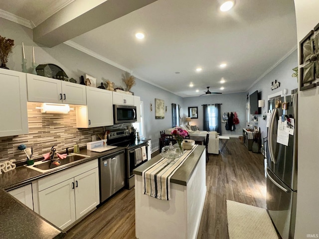 kitchen with crown molding, appliances with stainless steel finishes, decorative backsplash, and a sink