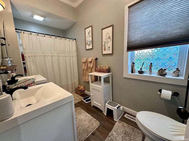full bath with baseboards, ornamental molding, visible vents, vanity, and wood finished floors