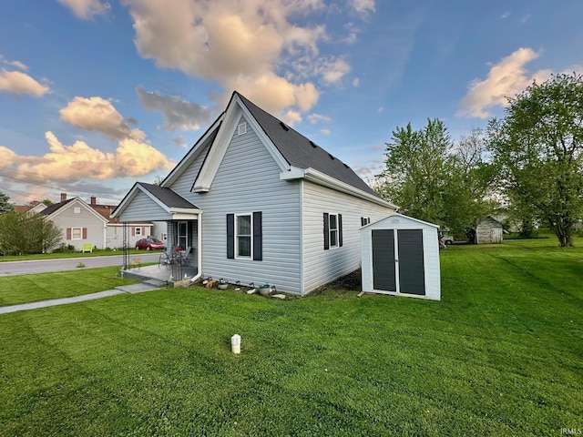back of property featuring a yard, a porch, an outdoor structure, and a storage unit