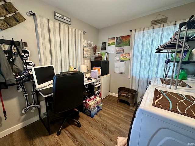 office area with baseboards, washer / dryer, and wood finished floors