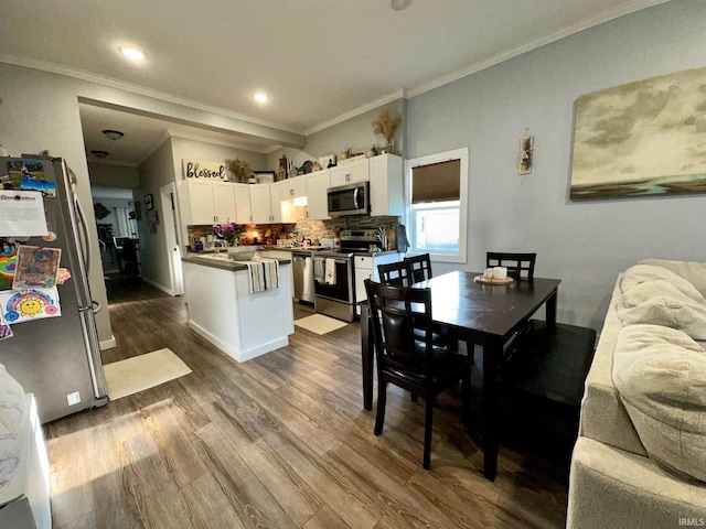dining area featuring dark wood-style flooring, ornamental molding, and recessed lighting