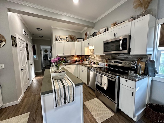 kitchen with white cabinets, decorative backsplash, dark countertops, and appliances with stainless steel finishes