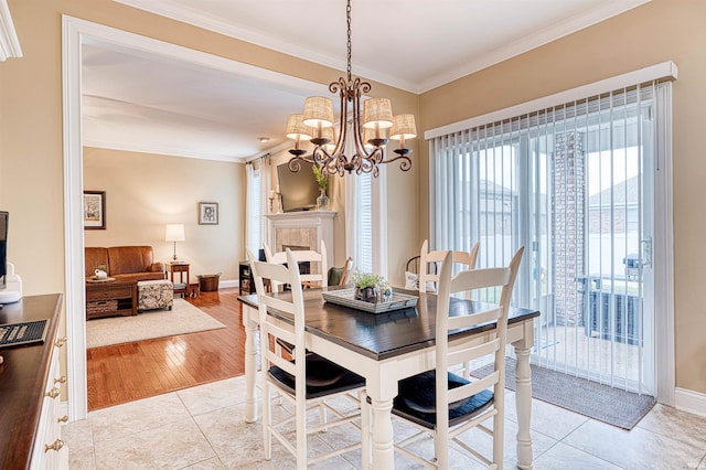 dining space with ornamental molding, a notable chandelier, and baseboards