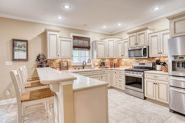 kitchen with cream cabinets, a peninsula, and stainless steel appliances