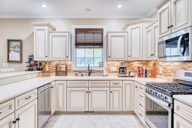 kitchen with light countertops, stainless steel appliances, tasteful backsplash, and a sink